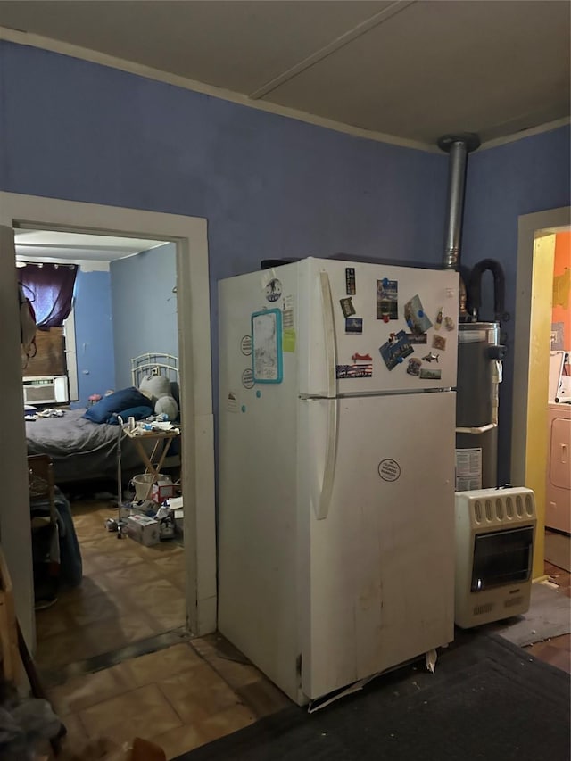 kitchen with washer / dryer, strapped water heater, heating unit, and freestanding refrigerator