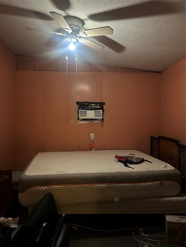 bedroom with ceiling fan, a wall mounted AC, and a textured ceiling