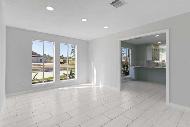 spare room with light tile patterned floors, visible vents, recessed lighting, and baseboards