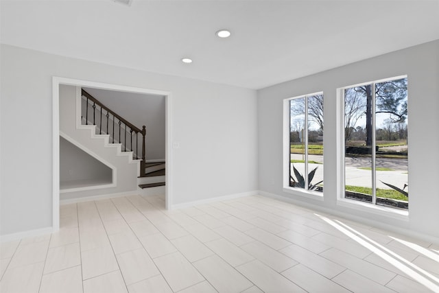 unfurnished room featuring stairs, recessed lighting, and baseboards