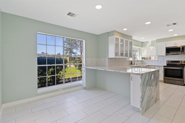 kitchen with visible vents, glass insert cabinets, appliances with stainless steel finishes, and white cabinets