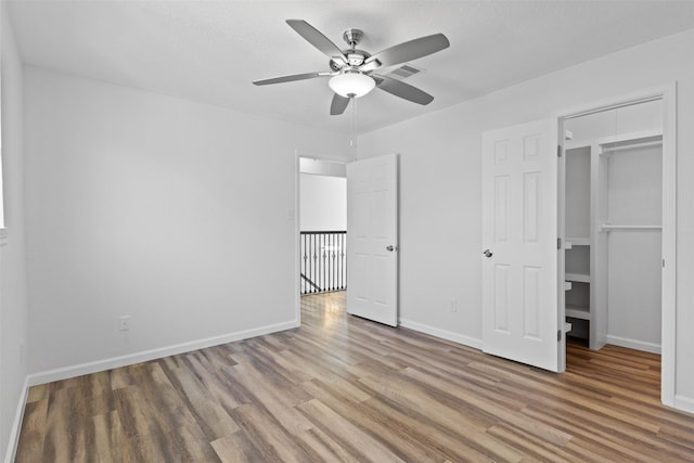 unfurnished bedroom with visible vents, baseboards, wood finished floors, and a ceiling fan