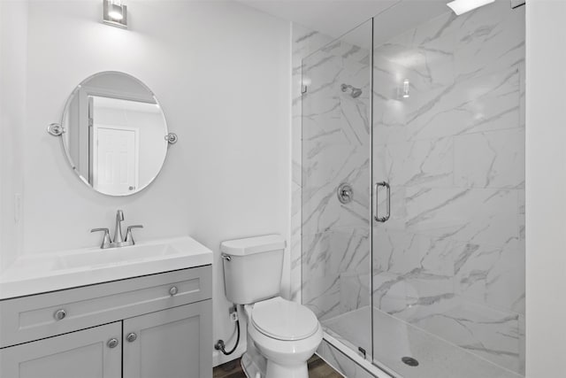 bathroom with a marble finish shower, toilet, and vanity