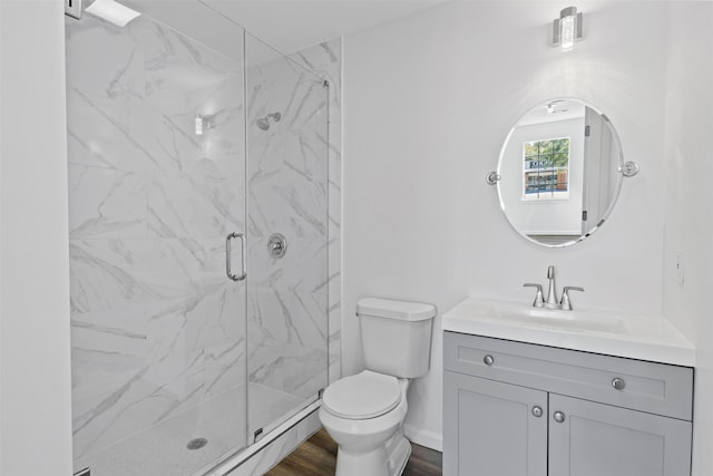 full bath with vanity, wood finished floors, baseboards, a marble finish shower, and toilet