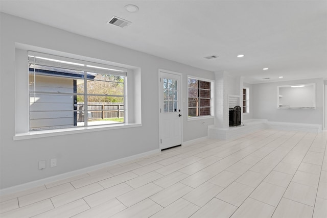 unfurnished living room with visible vents, recessed lighting, a brick fireplace, and baseboards