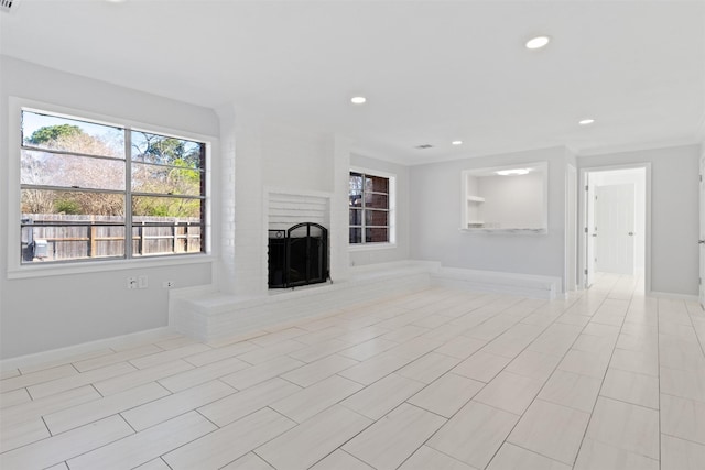 unfurnished living room featuring recessed lighting, baseboards, and a fireplace