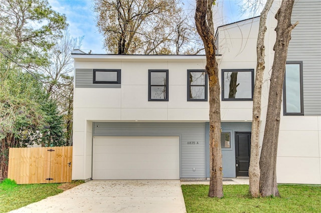 view of front of property featuring stucco siding, an attached garage, concrete driveway, and fence