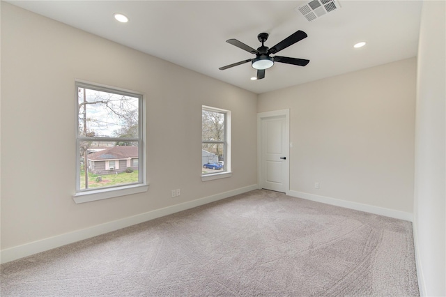 empty room with recessed lighting, light colored carpet, visible vents, and baseboards