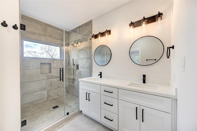 full bathroom featuring a sink, double vanity, a shower stall, and tile patterned floors