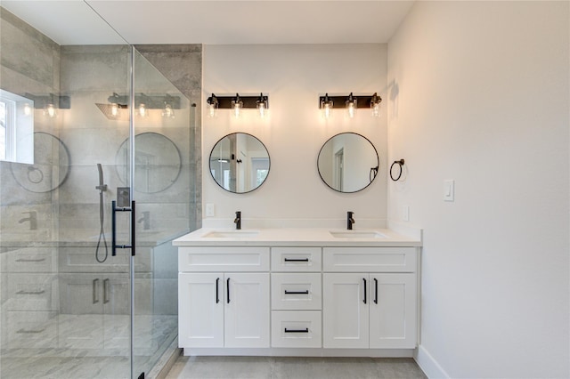 bathroom with double vanity, a stall shower, and a sink