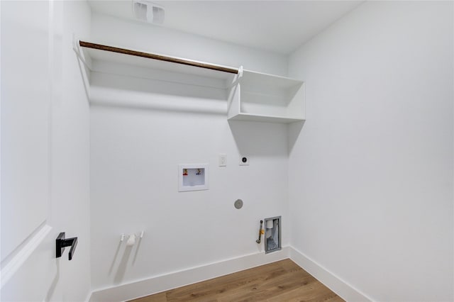 clothes washing area featuring wood finished floors, visible vents, hookup for an electric dryer, gas dryer hookup, and laundry area