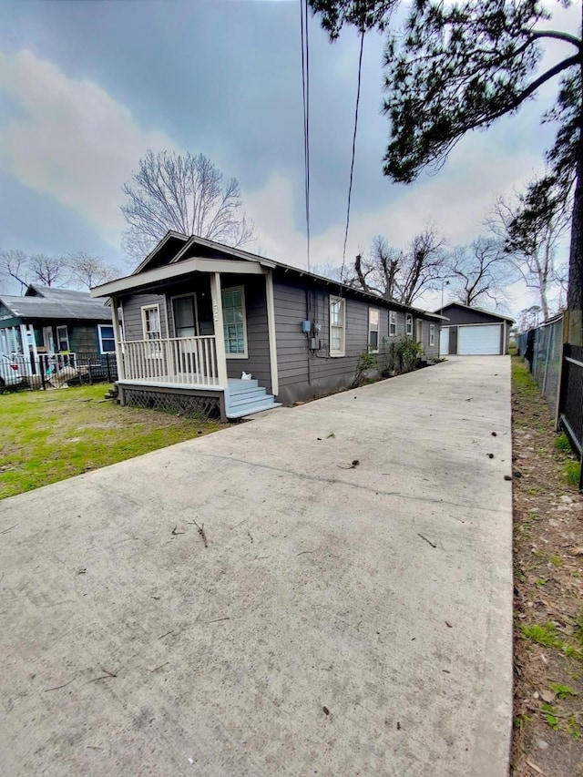 ranch-style home with fence, a front yard, covered porch, a garage, and an outdoor structure