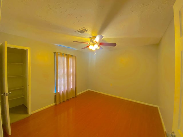 132 Grothe Ln, Houston, TX 77022 - empty room featuring wood finished floors, baseboards, a ceiling fan, and a textured ceiling