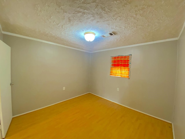 132 Grothe Ln, Houston, TX 77022 - empty room with wood finished floors, crown molding, a textured ceiling, and baseboards