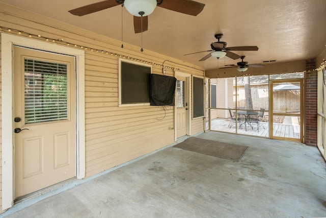 unfurnished sunroom with plenty of natural light, a ceiling fan, and visible vents