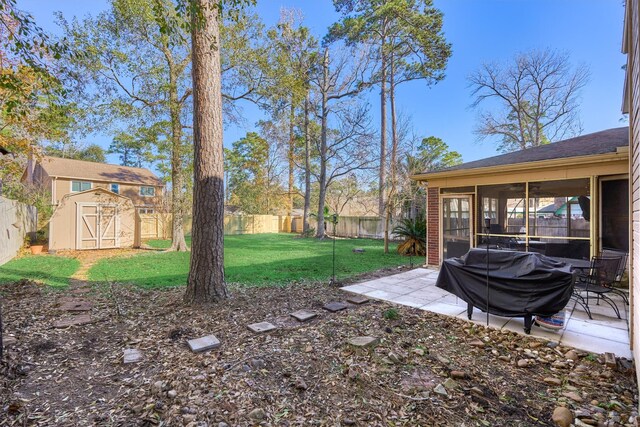 view of yard featuring an outbuilding, a patio, a fenced backyard, a sunroom, and a storage shed