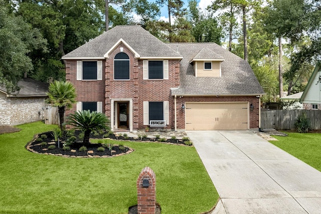 colonial home with fence, driveway, roof with shingles, a front lawn, and brick siding