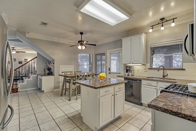 kitchen featuring a sink, stainless steel appliances, light tile patterned flooring, crown molding, and decorative backsplash