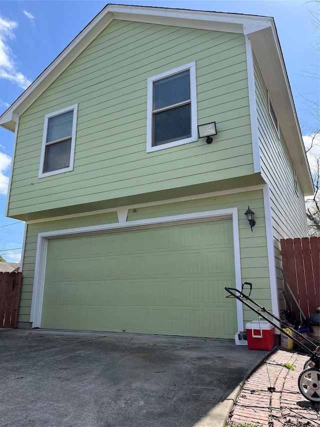 garage with driveway and fence