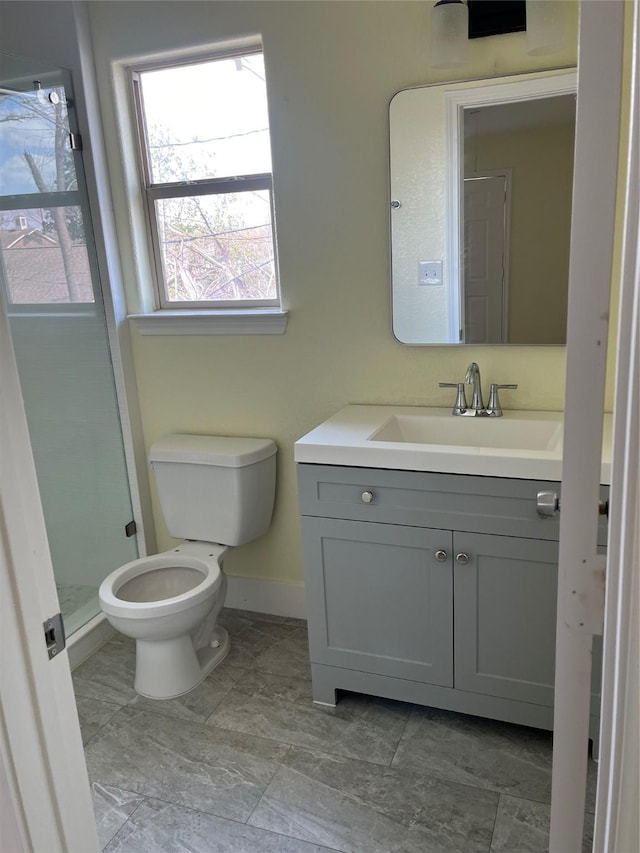 full bathroom with a shower stall, toilet, vanity, and baseboards