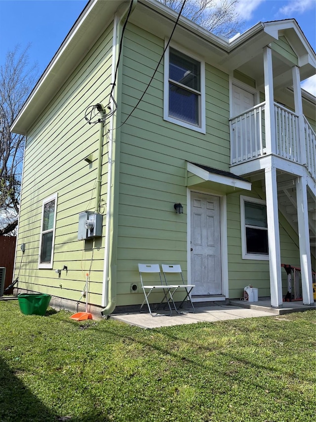 rear view of house with a yard and a patio