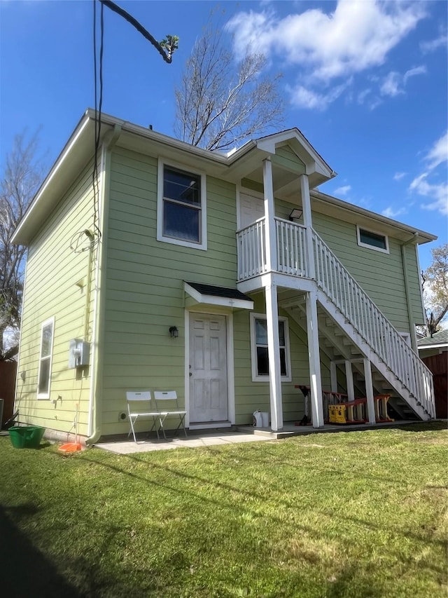 back of house with stairs, a patio, and a yard