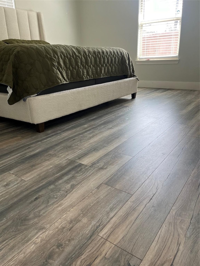 bedroom with baseboards and wood finished floors