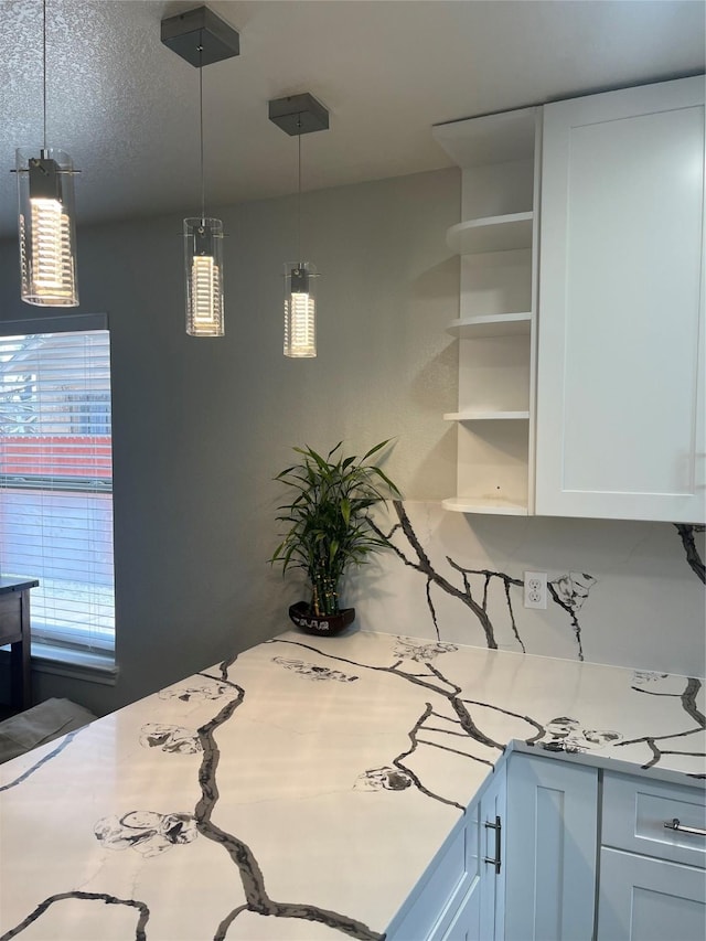 kitchen featuring open shelves, white cabinetry, light countertops, and hanging light fixtures