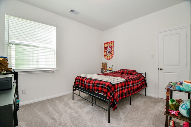 carpeted bedroom featuring baseboards and visible vents