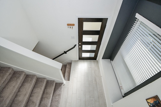 entryway with wood finished floors and stairs