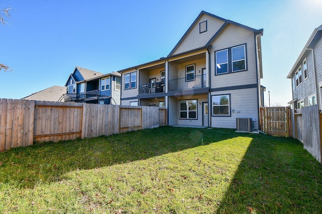 back of property with a fenced backyard and a yard