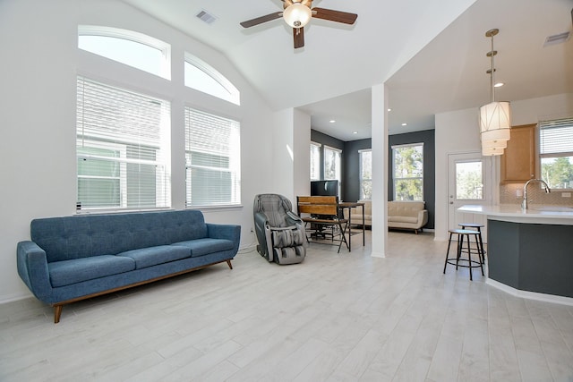 living room with lofted ceiling, light wood-style flooring, and visible vents