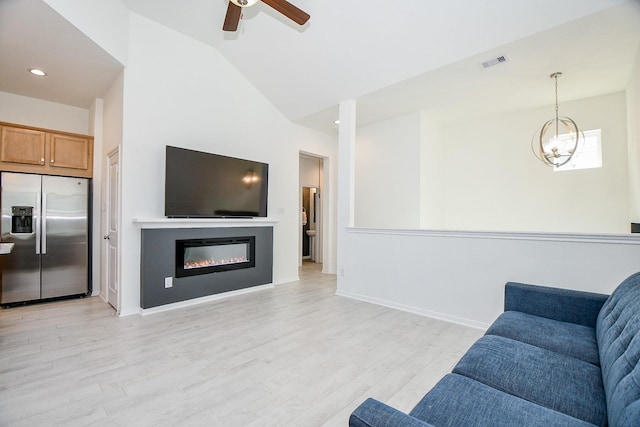 living room with baseboards, visible vents, lofted ceiling, ceiling fan with notable chandelier, and light wood-type flooring