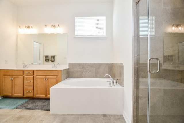 full bath with a shower stall, a garden tub, double vanity, and a sink