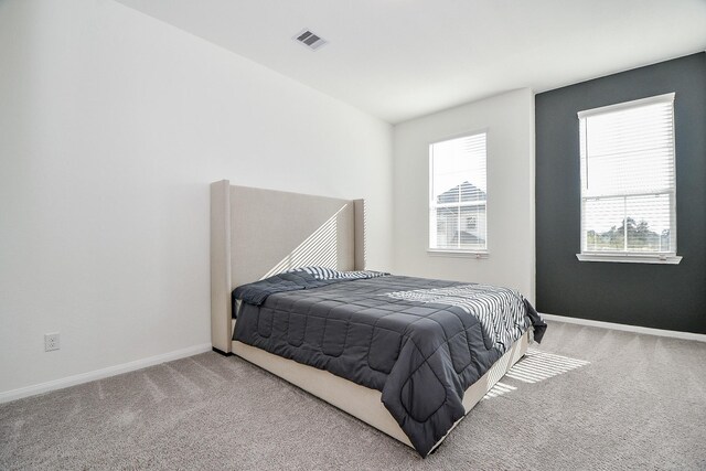 bedroom with visible vents, baseboards, and carpet