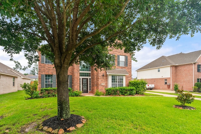 view of front of property with a front lawn and brick siding