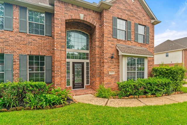 view of exterior entry with brick siding