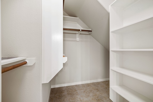 spacious closet with tile patterned flooring and vaulted ceiling