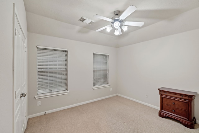 unfurnished bedroom featuring a ceiling fan, carpet, visible vents, and baseboards