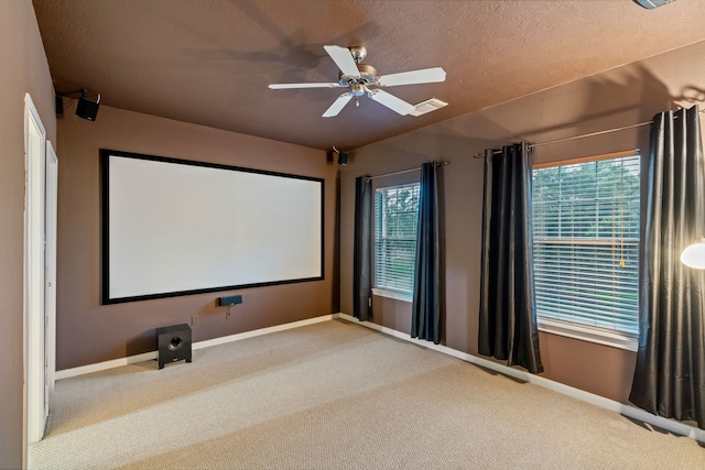 carpeted cinema featuring a wealth of natural light, ceiling fan, and baseboards