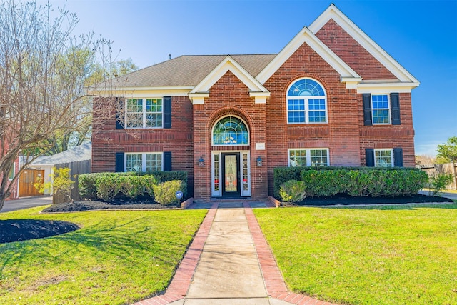 view of front of home with brick siding and a front yard