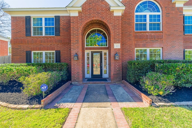 entrance to property featuring brick siding