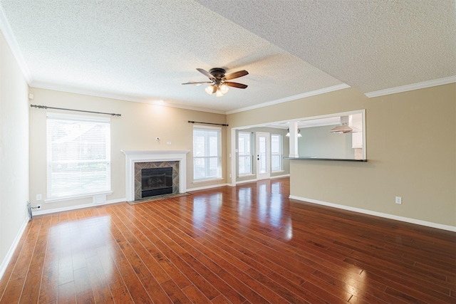 unfurnished living room featuring ornamental molding, a ceiling fan, hardwood / wood-style floors, a fireplace, and baseboards