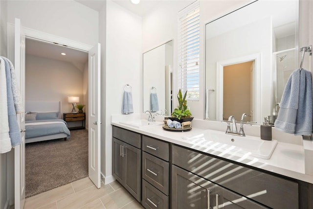 ensuite bathroom featuring double vanity, ensuite bathroom, a shower stall, and a sink