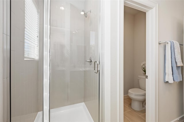 full bath featuring tile patterned floors, a stall shower, and toilet