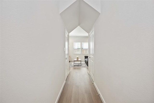 hallway featuring light wood-type flooring and baseboards