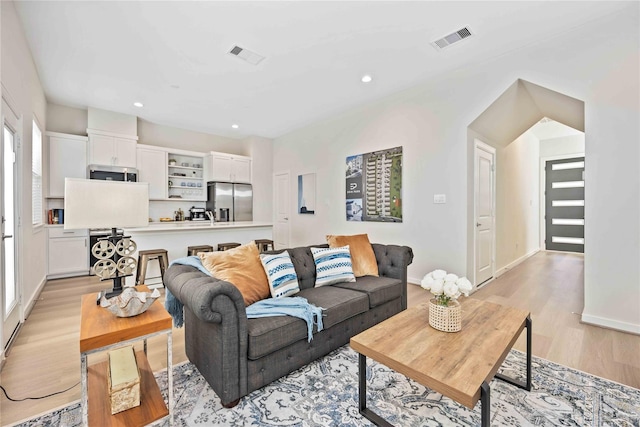 living room featuring recessed lighting, visible vents, baseboards, and light wood-style floors