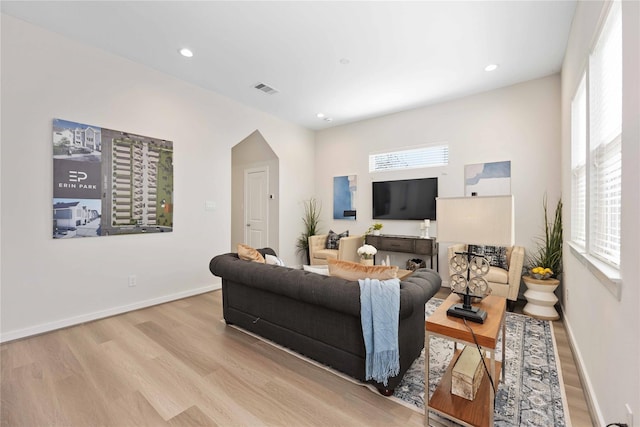 living area featuring visible vents, baseboards, and wood finished floors