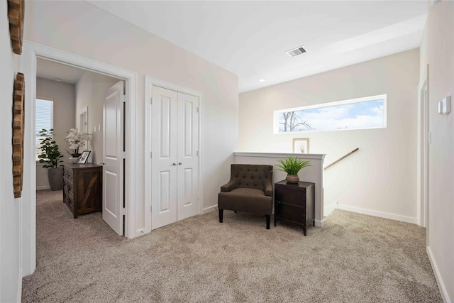 sitting room featuring an upstairs landing, carpet, visible vents, and baseboards