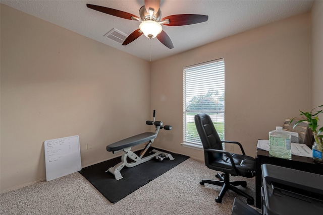 home office featuring visible vents, a textured ceiling, a ceiling fan, and carpet floors